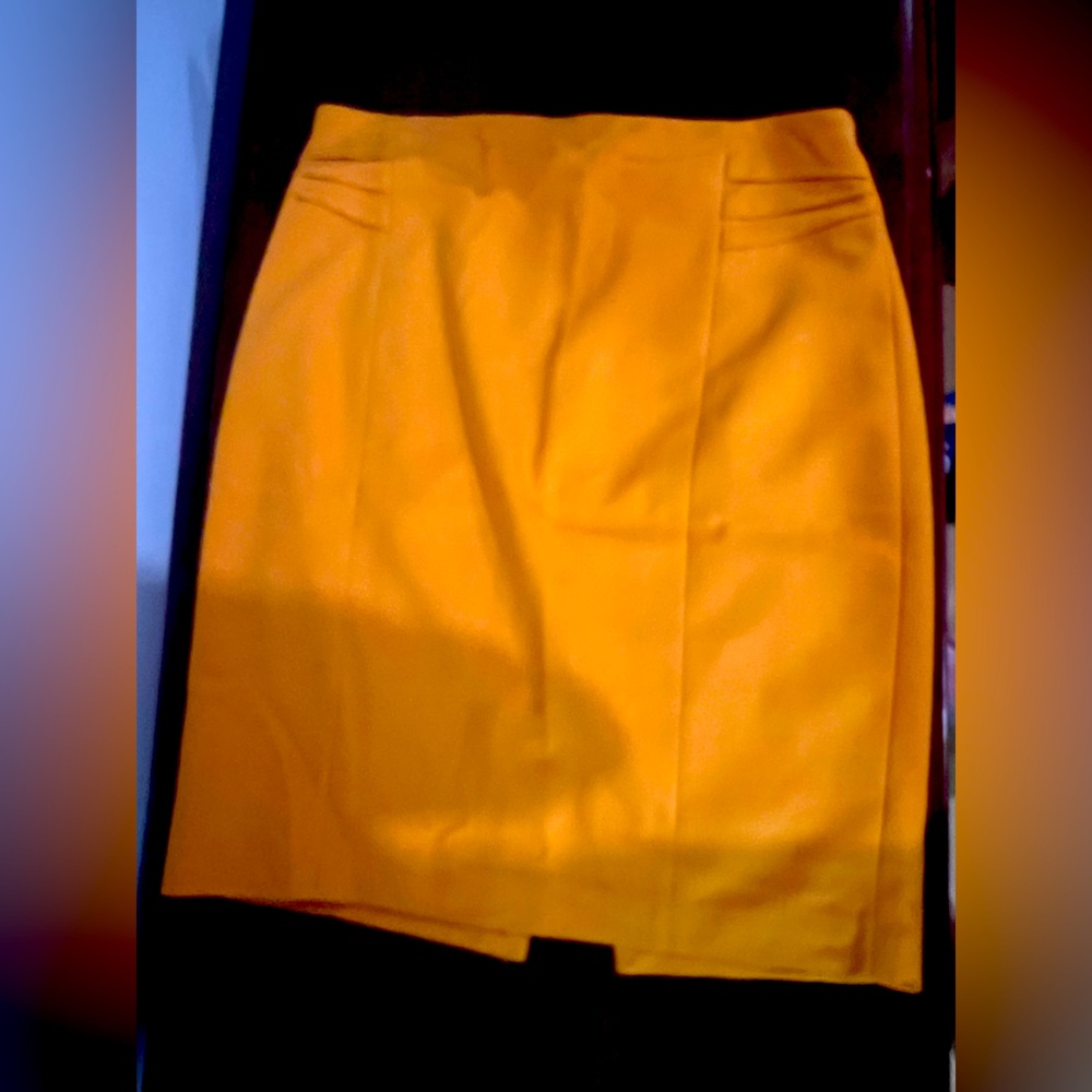 Yellow express pencil skirt with small slit in back and detailing on hips.